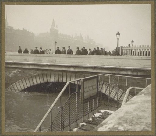 People viewing the high water level in the Seine from a bridge during the flooding of Paris