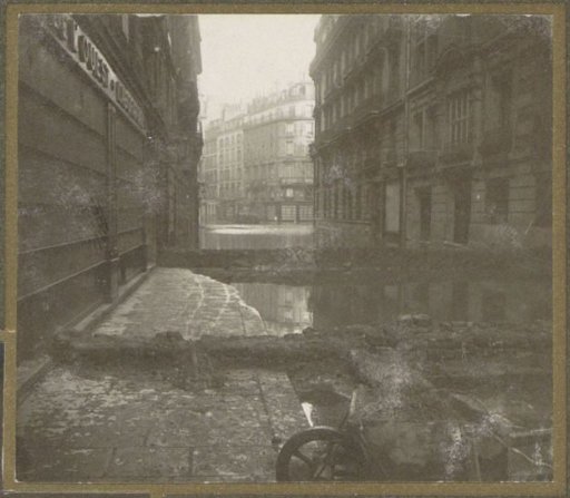 Flooded street with dams and a wheelbarrow