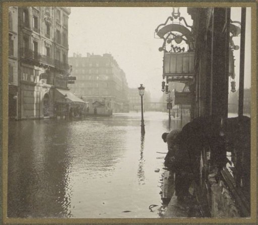 Pedestrians on a plank walkway in a flooded street