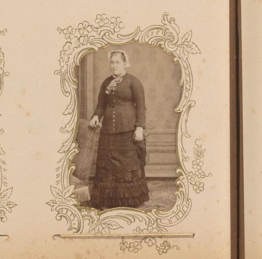 Portrait of a Woman with a Traditional Cap Standing by a Chair