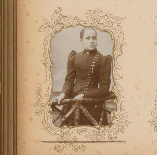 Portrait of a young woman standing by a fence