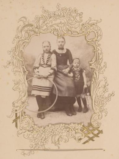 Group portrait of three children with a hoop
