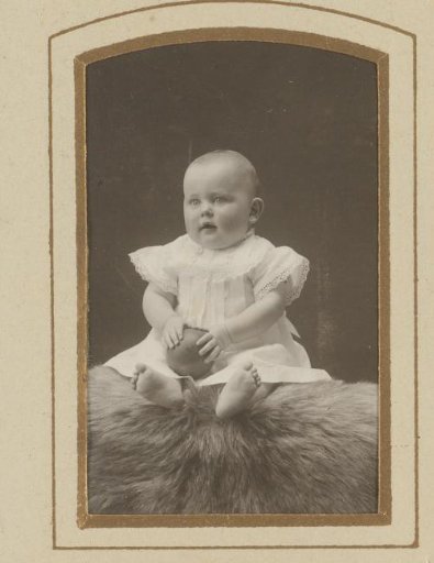 Portrait of a seated baby with a ball