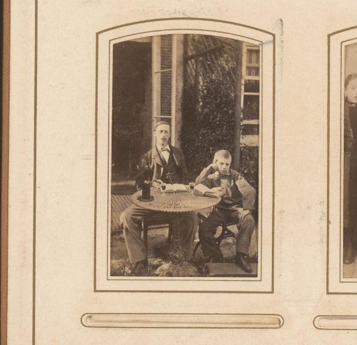 Portrait of a man and a boy, seated at a table on a terrace