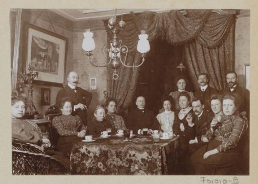 Men and women behind a table in a living room