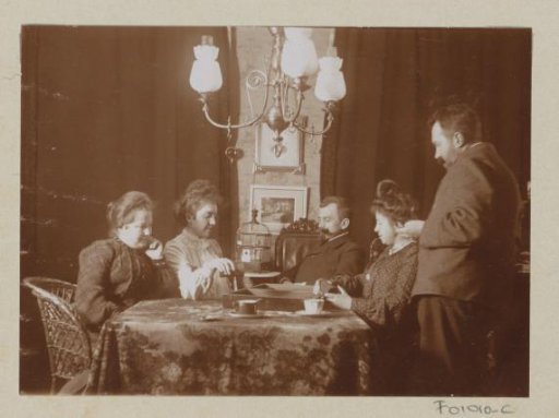 Men and women playing a board game in a living room