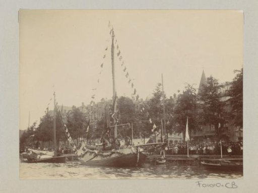 Spectators at decorated boats on the Amsteldijk