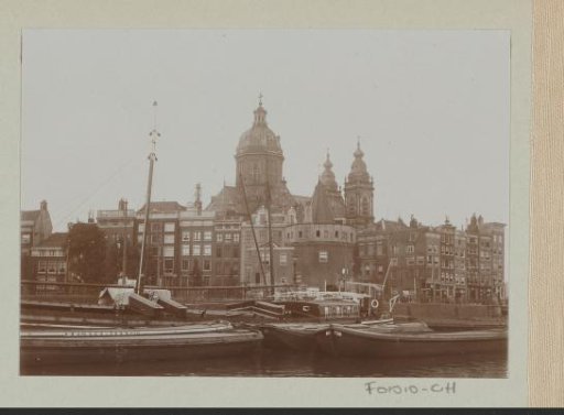 Ships moored at the Prins Hendrikkade with the Sint-Nicolaaskerk and the Schreierstoren in Amsterdam in the background