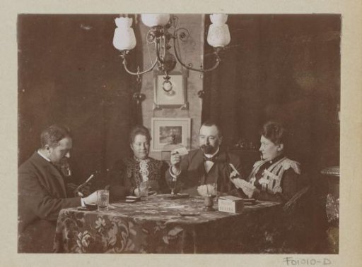 Men and women playing a board game in a living room