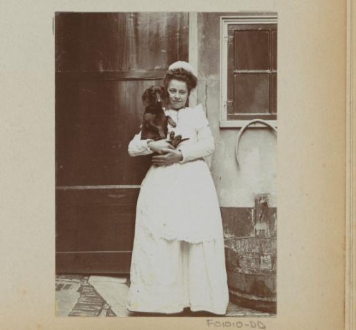 Maid holding a poodle at an outdoor tap