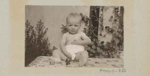 Baby touching belly and between the legs, seated on a table