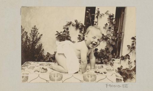 Baby crawling on a tablecloth in a garden