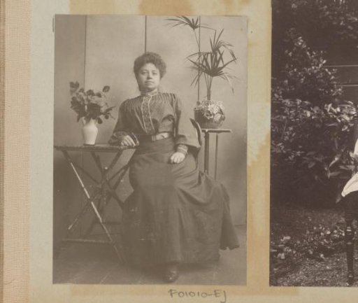 Woman seated at tables with a plant and flowers