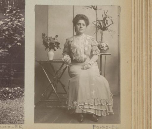 Woman seated at tables with a plant and flowers