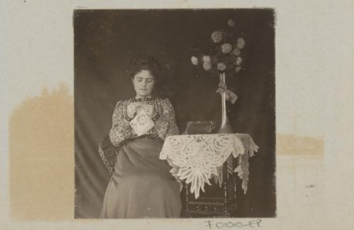 Woman chopping at a table with a tablecloth and flowers