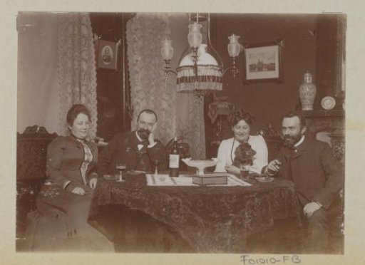 Two men and two women seated around a table with glasses of wine