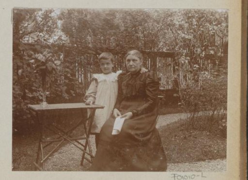 Woman with a child at a table in a garden