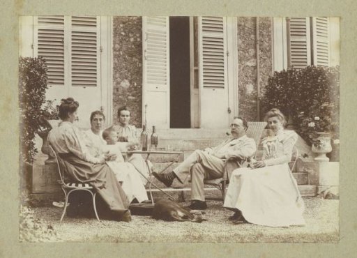 Women, a man, a baby and a dog posing in a garden