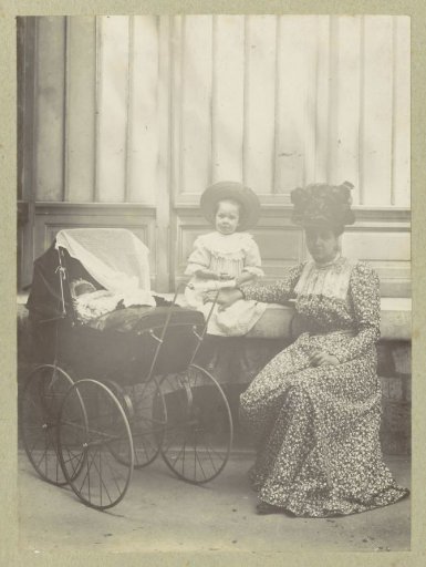 Portrait of a woman with a child and a baby in a pram
