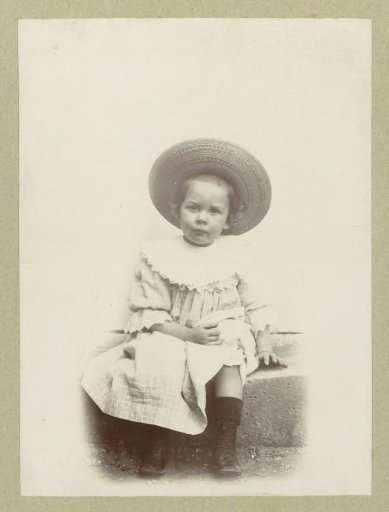 Portrait of a child in a dress and a sun hat