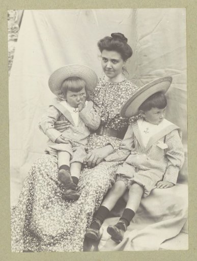Portrait of a woman with two children wearing sun hats and sailor suits