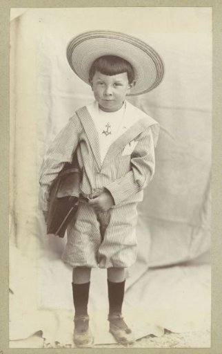 Portrait of a child with a bag, a sailor suit and a sun hat
