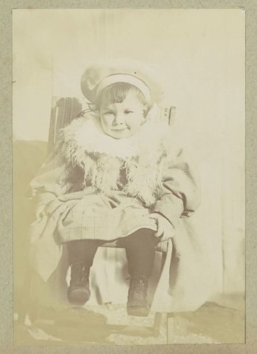 Portrait of a young child with a jacket, a scarf and a cap