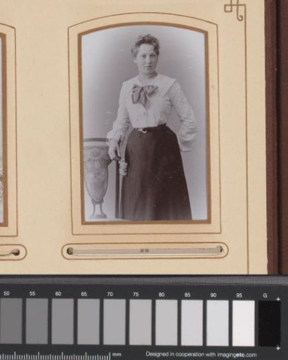Portrait of a woman, standing by a chair