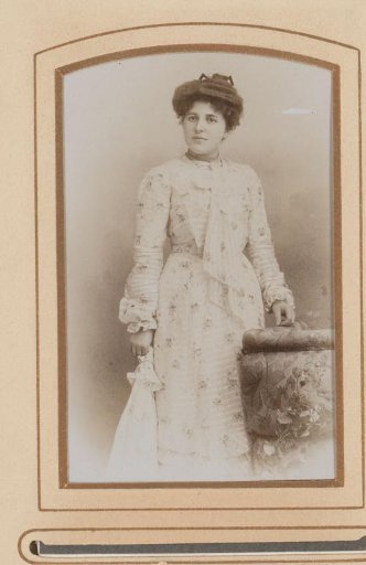Portrait of a woman standing by a chair