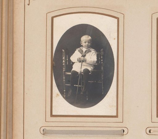 Portrait of a boy with walking stick, seated on a chair