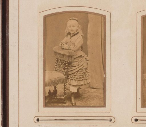 Portrait of a girl standing by a chair