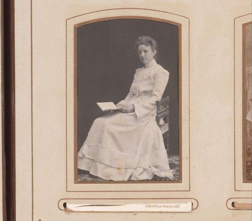 Portrait of a young woman seated with a book