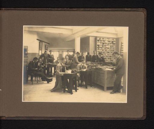 Group of men inspecting tobacco in a warehouse, presumably N.V. Het Nederlandsche Veem