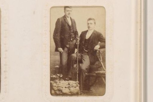 Portrait of a standing man with a walking stick and a seated man with spectacles, a cigar and a walking stick