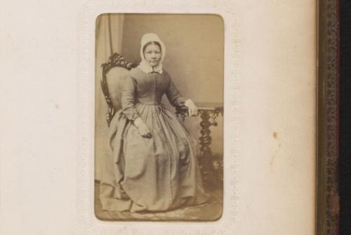 Portrait of a seated woman with a white cap