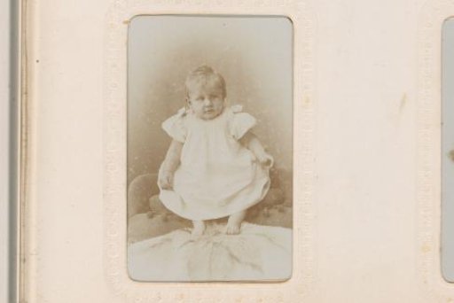 Portrait of a Baby in a White Dress and Cap