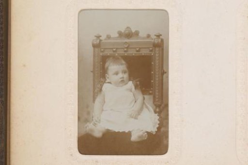 Portrait of a Girl with a Bucket in Her Hand, Standing by a Chair with a Doll