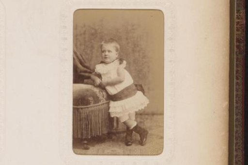 Portrait of a Boy Standing Behind a Fence