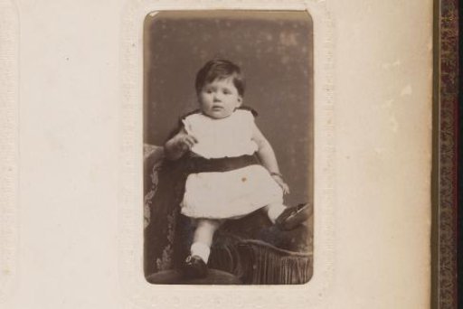 Portrait of a Girl Standing Beside a Chair with a Doll