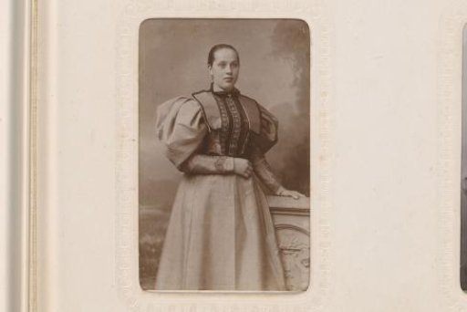 Portrait of a standing young woman in a dress with puffed sleeves