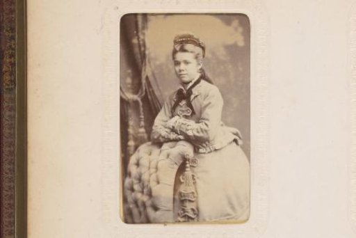 Portrait of a standing young woman leaning on the back of a chair