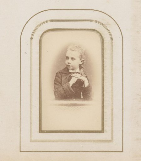 Portrait of a man, seated at a table with a book and tall hat