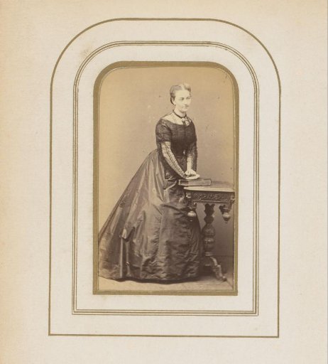 Portrait of a woman standing at a table with a book