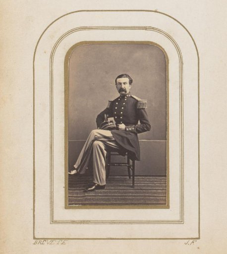 Portrait of a seated man in uniform with a cap