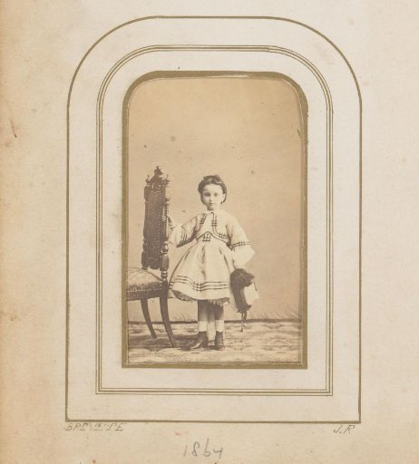 Portrait of a girl with a hat, standing by a chair, identified as Marie Coche