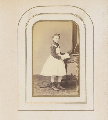Portrait of a girl, standing by a table with a book