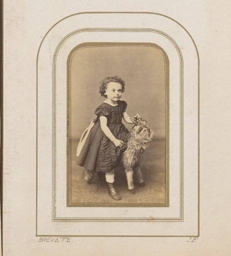 Portrait of a Girl Sitting on a Toy Animal