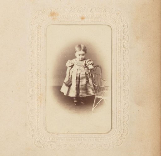 Portrait of a girl standing by a chair