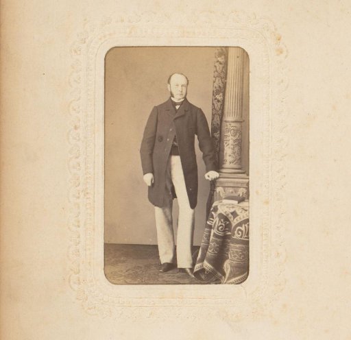 Portrait of a man standing by a pillar