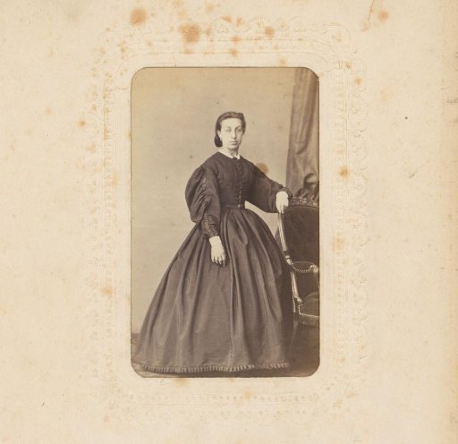 Portrait of a woman standing by a chair